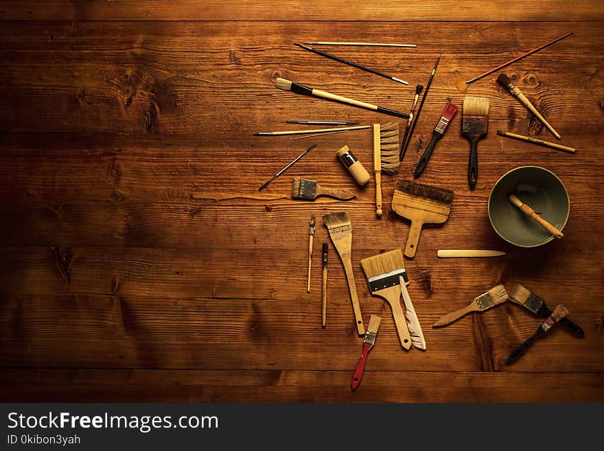 Painting still life with lot of type brushes and other tools on a wooden background