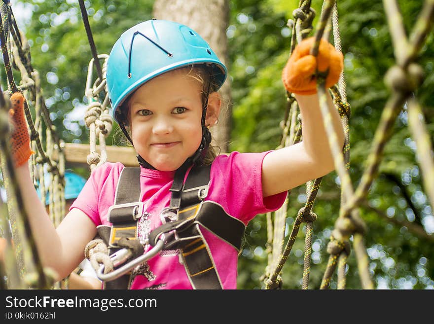 Five year girl on rope-way in the forest