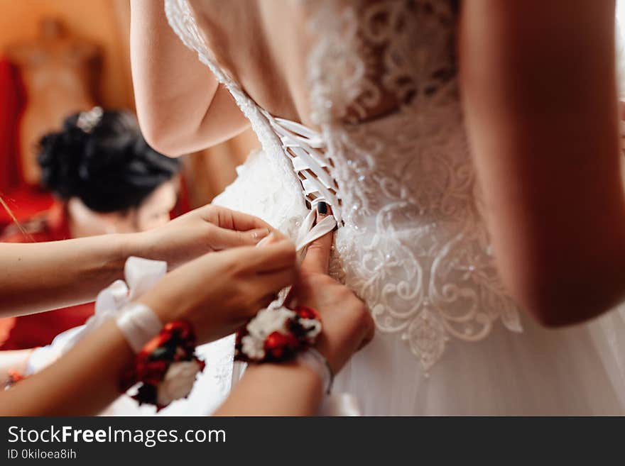 Wedding morning women`s hands fasten the bride`s corset. Wedding morning women`s hands fasten the bride`s corset