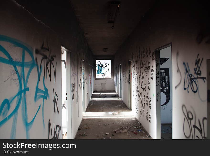 Empty Hallway With Black and Blue Graffiti