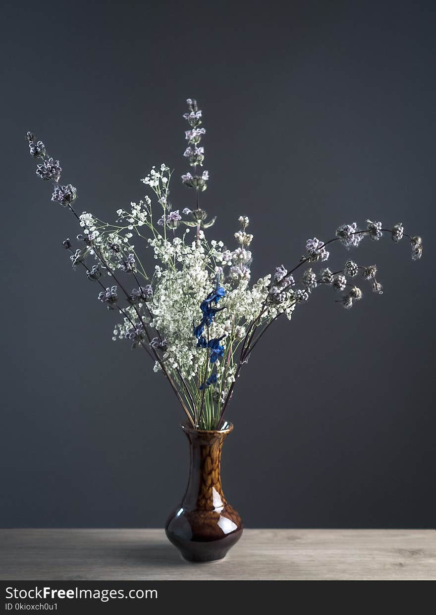 Shallow Focus Photography of White and Gray Flowers in Brown Ceramic Vase