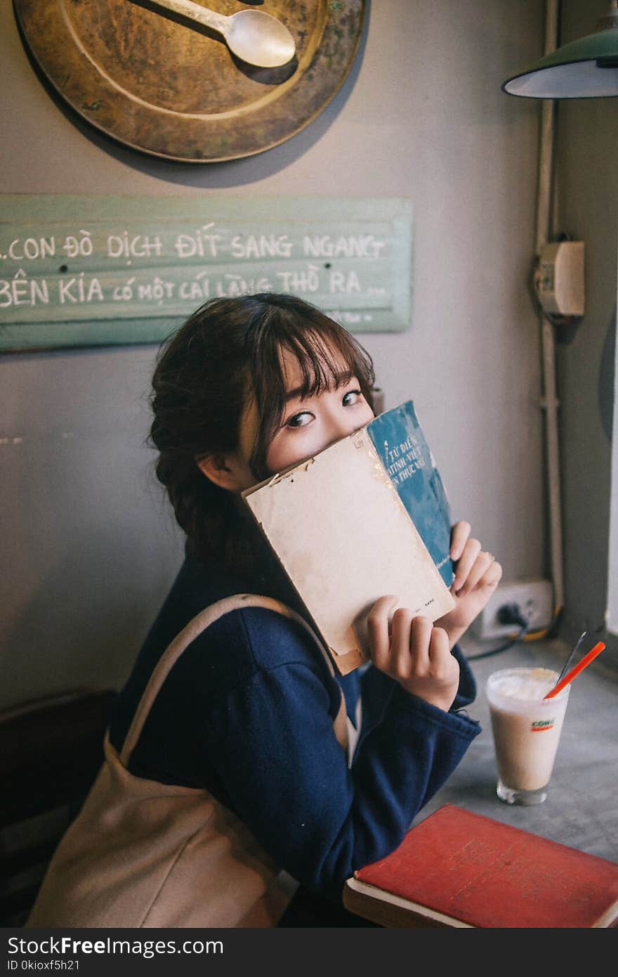 Woman Sitting on Chair Holding Abook