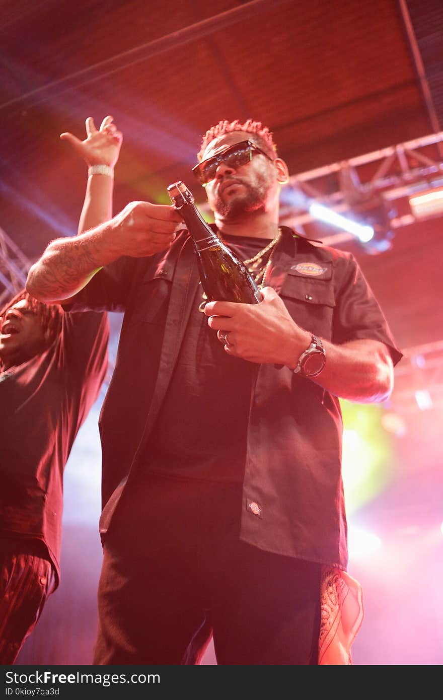 Man Wearing Black Collared Top Holding Bottle