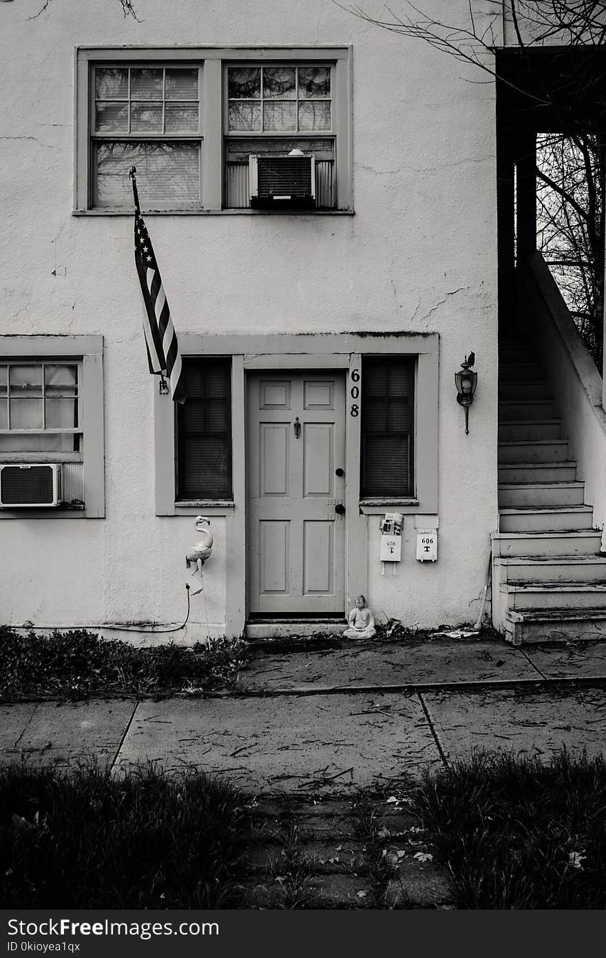 Grayscale Photo of Concrete House With Usa Flag