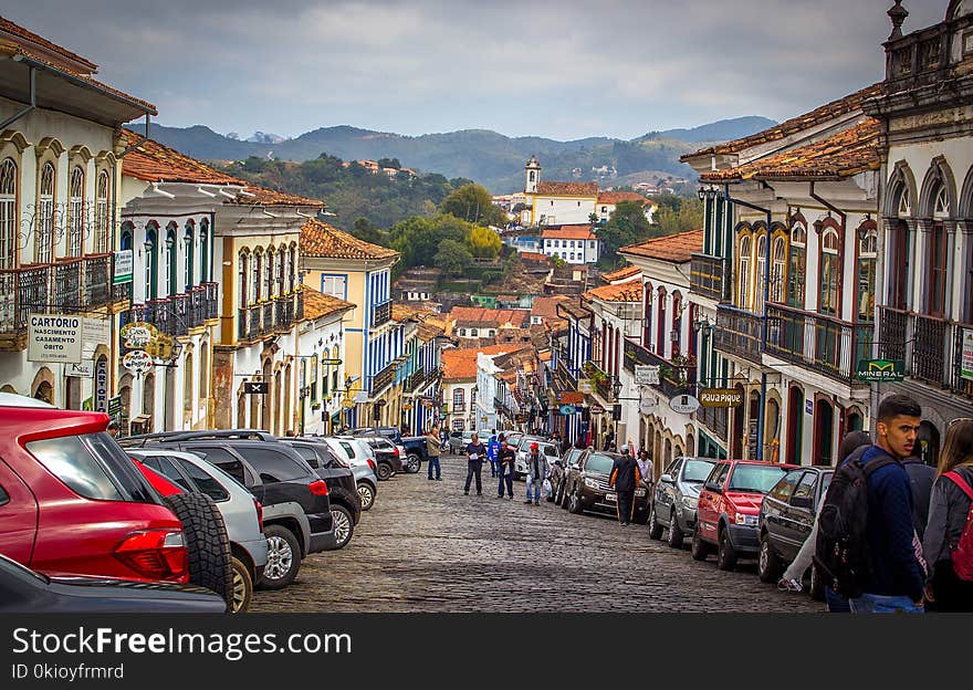 People Walking on the Streets Surrounded by Cars and Buildings