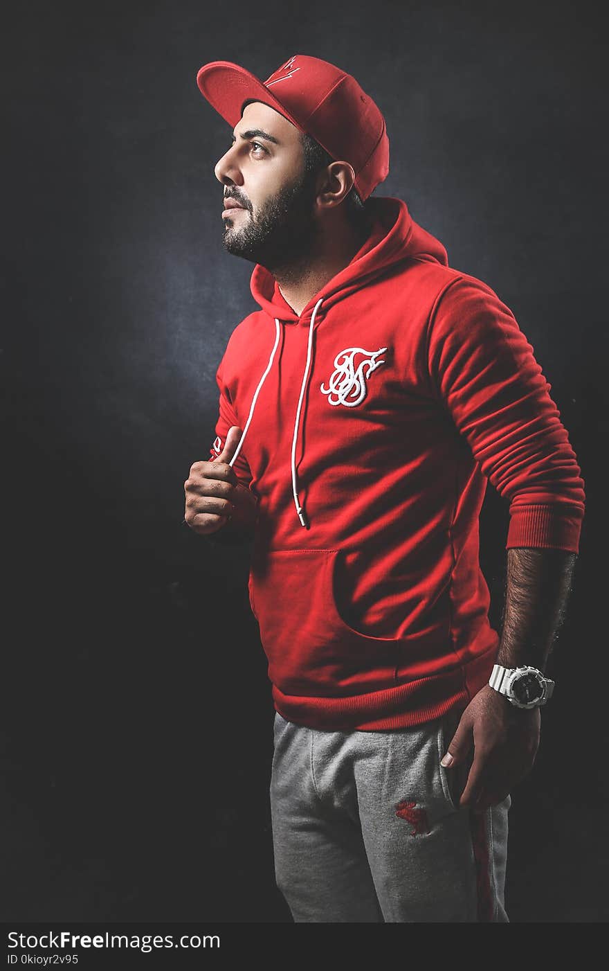 Man Wearing Red Pullover Hoodie and Gray Pants