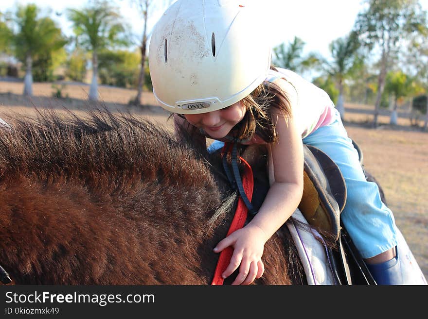 Girl in Blue Pants Riding Brown Animal