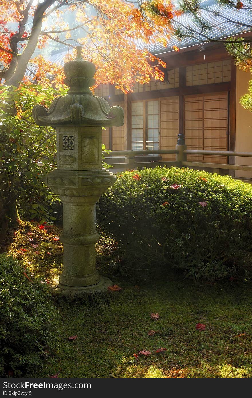 Sun beams over stone pagoda lantern by the pavilion at Japanese Garden during fall season. Sun beams over stone pagoda lantern by the pavilion at Japanese Garden during fall season