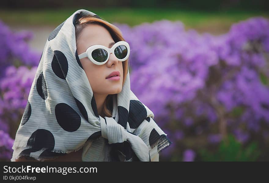 Girl In White Shawl Near Purple Flowers