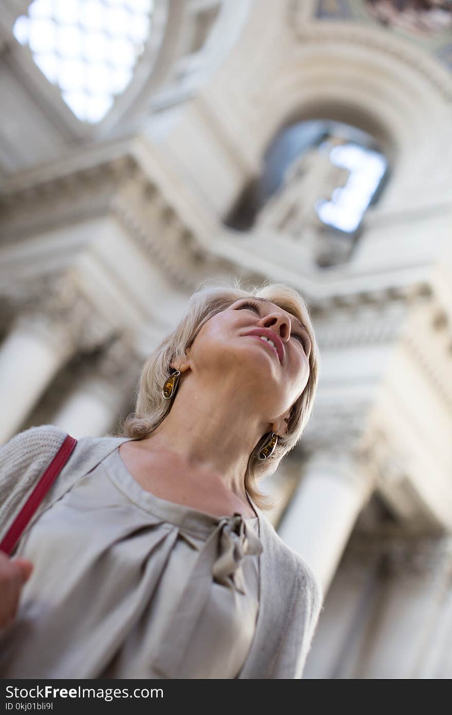 Mature woman examines the exhibit in historical museum. Mature woman examines the exhibit in historical museum