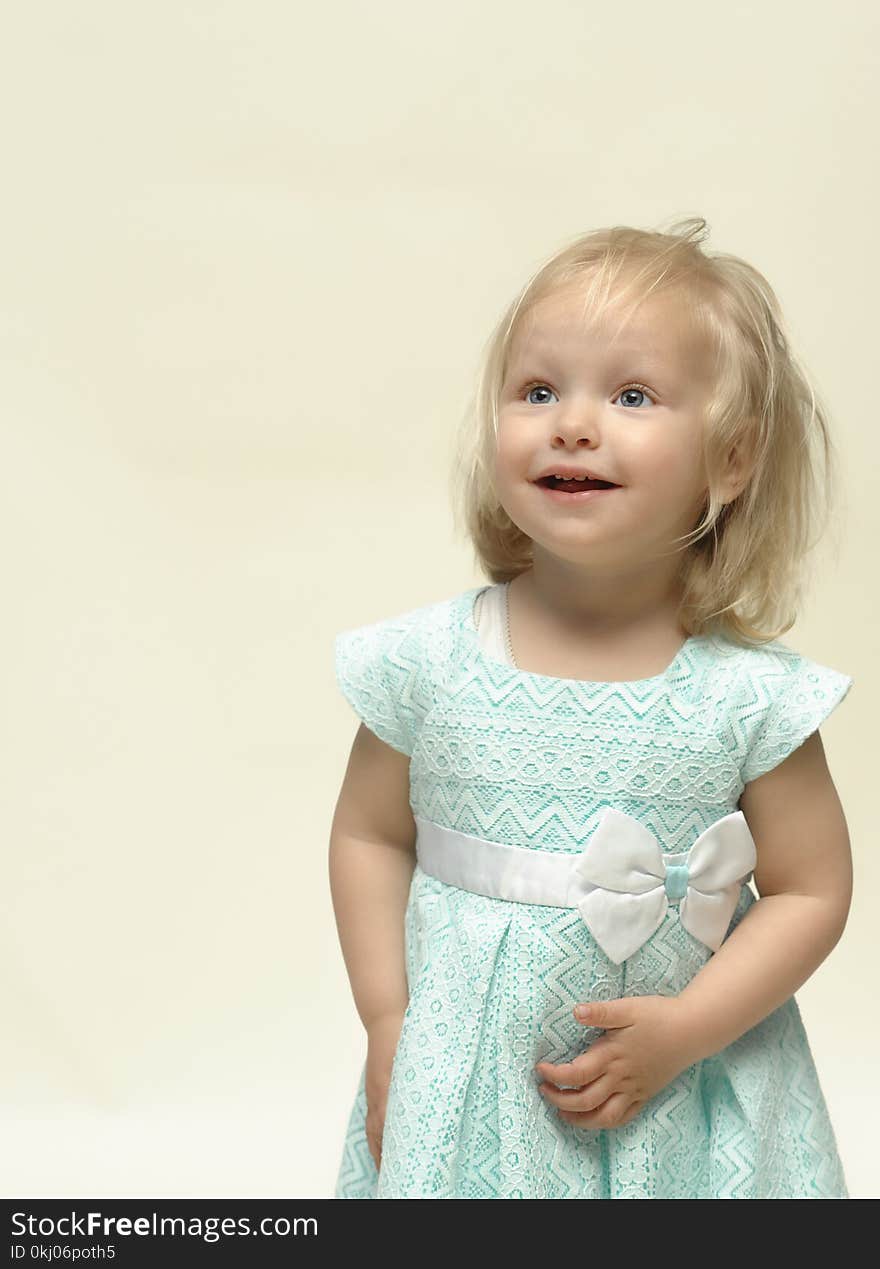 Portrait of a cheerful child with a big smile and a cute blue dress. Portrait of a cheerful child with a big smile and a cute blue dress