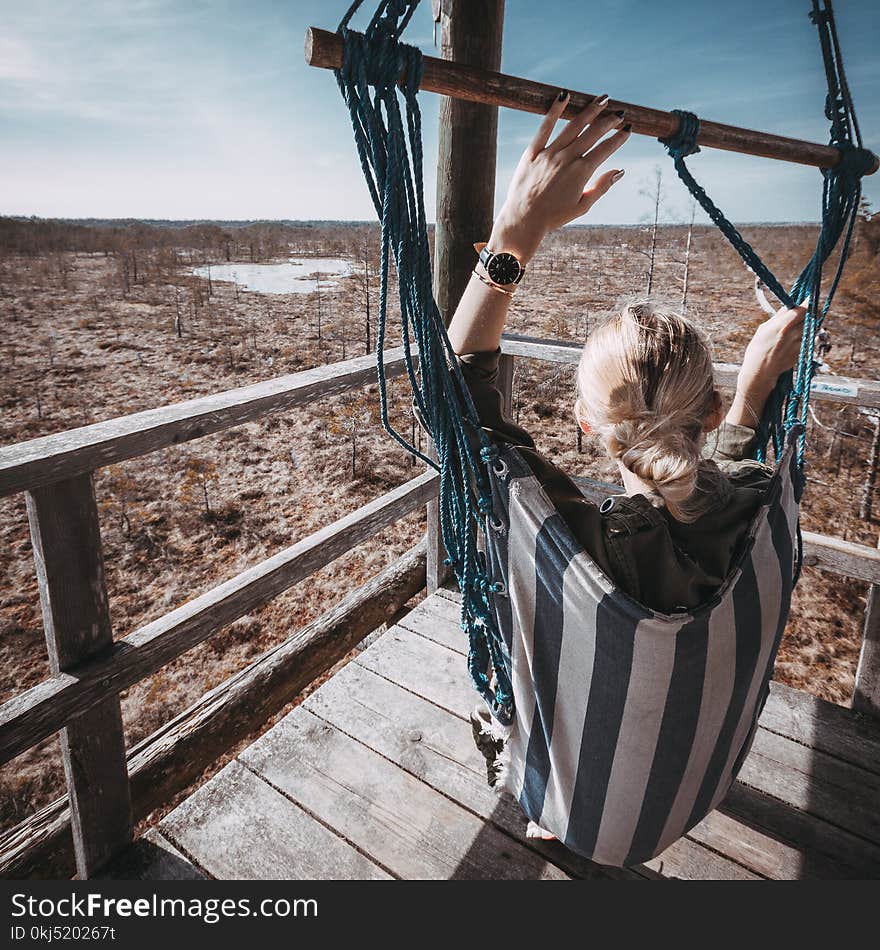 Woman With Blonde Hair On Blue And White Striped Hammock