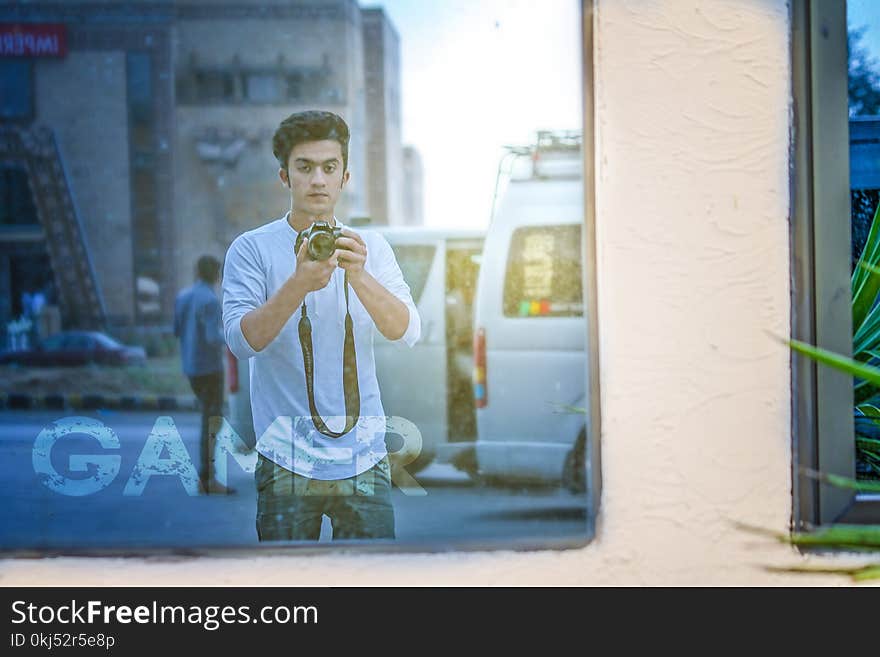 Man Wearing White Shirt And Holding Camera