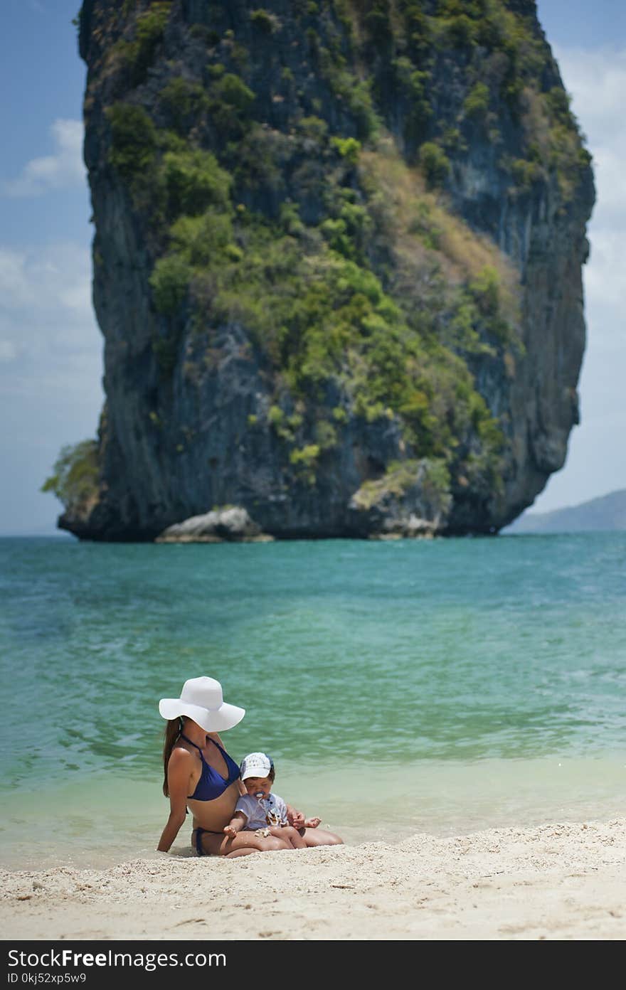 Tilt Shift Photography Of Woman And Son On Beach