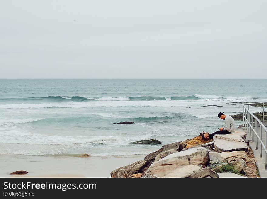 Man Sitting On Rocks