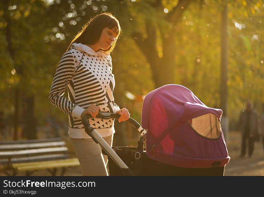 Woman Holding Pink And Black Stroller