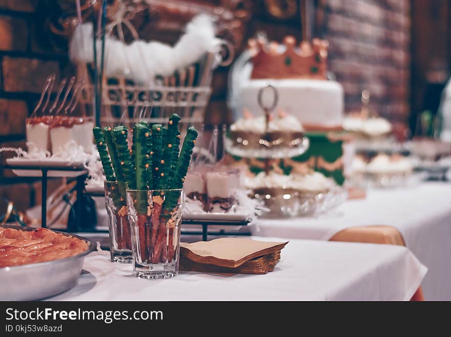 Baked Bread Beside Clear Drinking Glass on White Table Cover