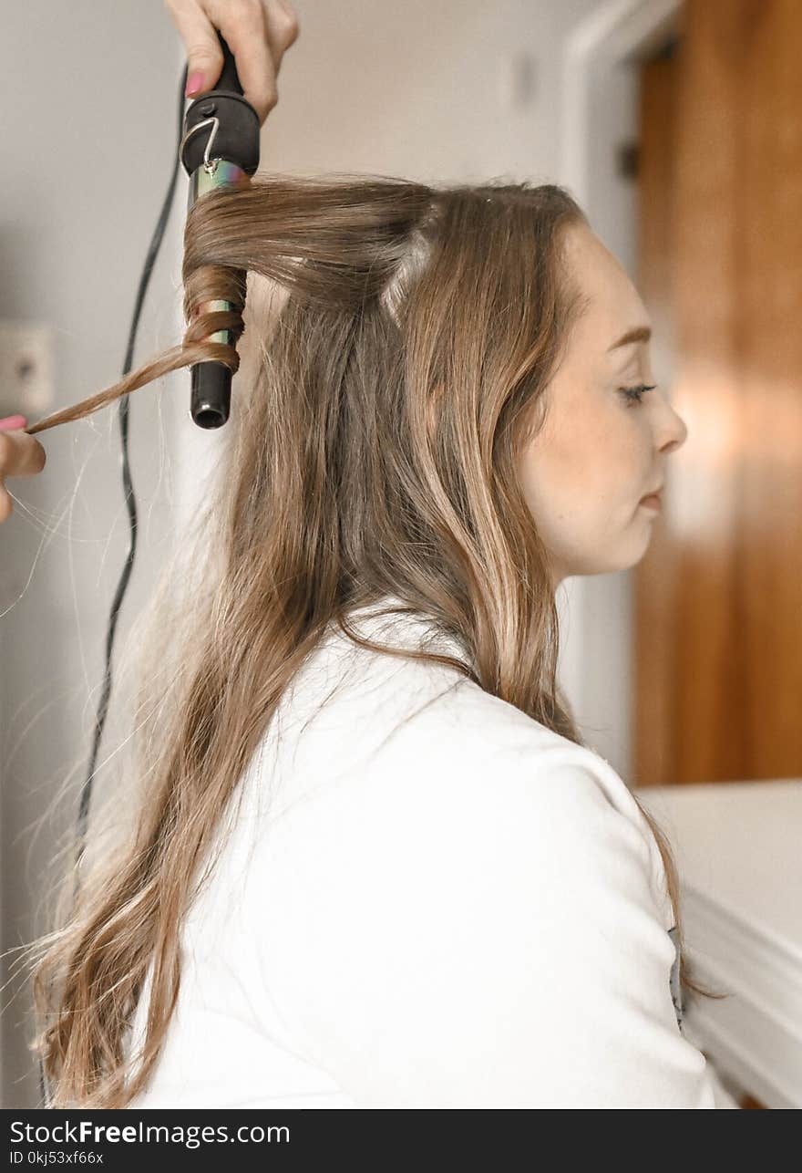 Woman Curling Her Hair