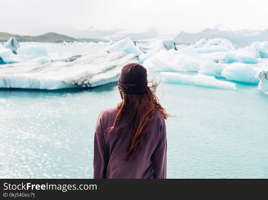 Woman Wearing Purple Shirt Overlooking at Body of Water and Snow Covered Field