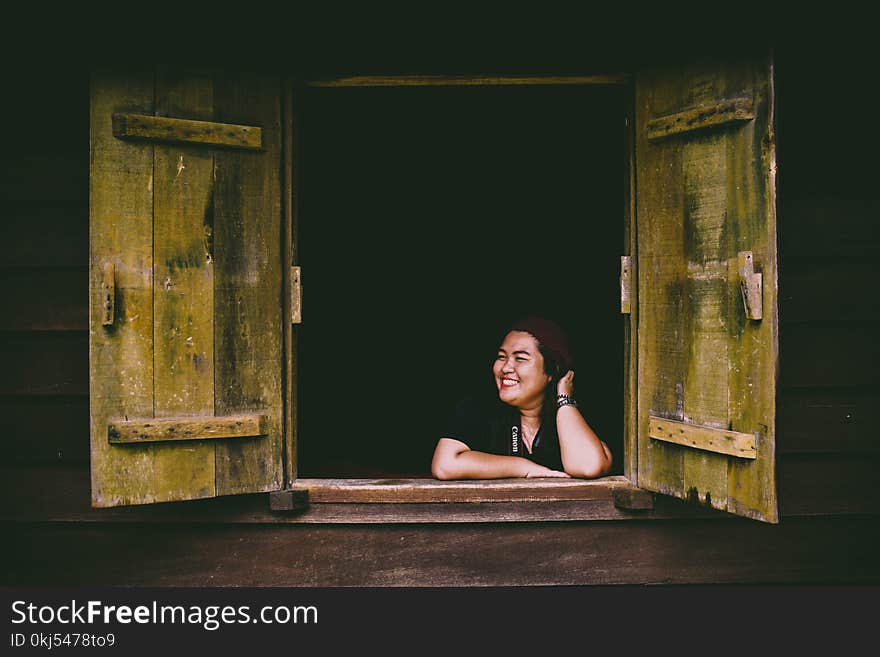 Woman in Black Top Sitting in Front of Opened 2-door Panel Window