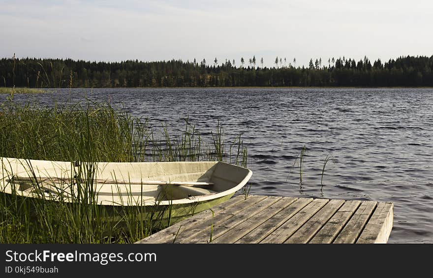 Brown Wooden Dock Beside White and Green Boat