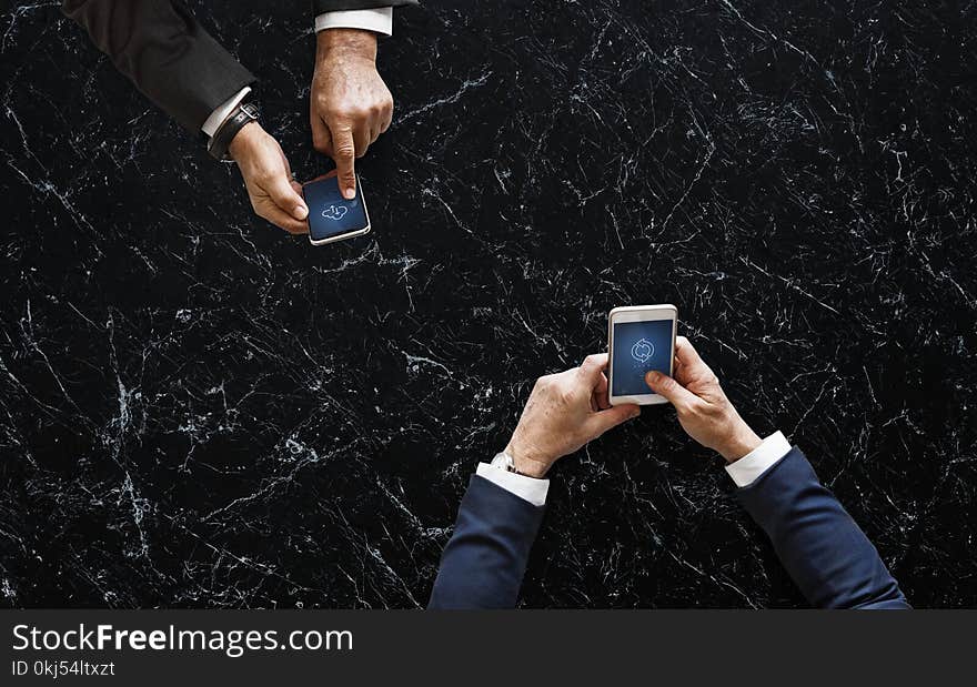 Two Person Holding White and Black Android Smartphones