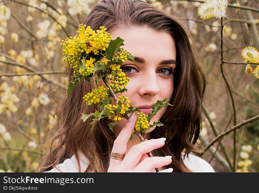 Woman Taking Photo With Holding Yellow Flower Buds at Daytime