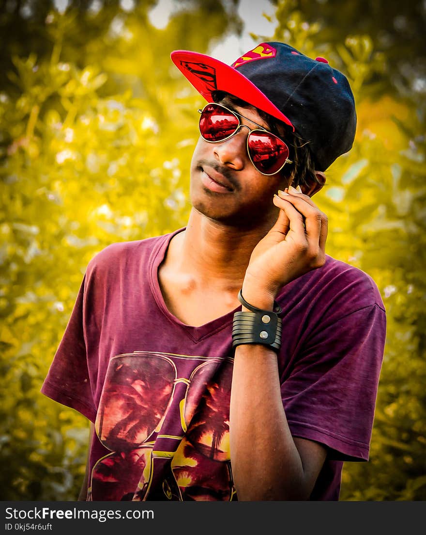 Man Wearing Red and Black Fitted Cap and Purple Crew-neck T-shirt Photo