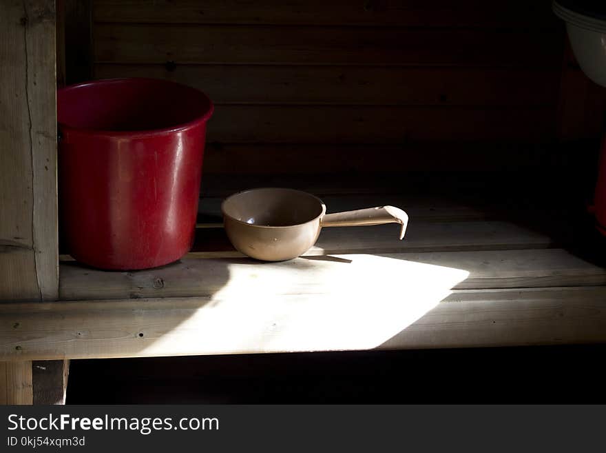 Red Bucket and Beige Dipper on Brown Wooden Table