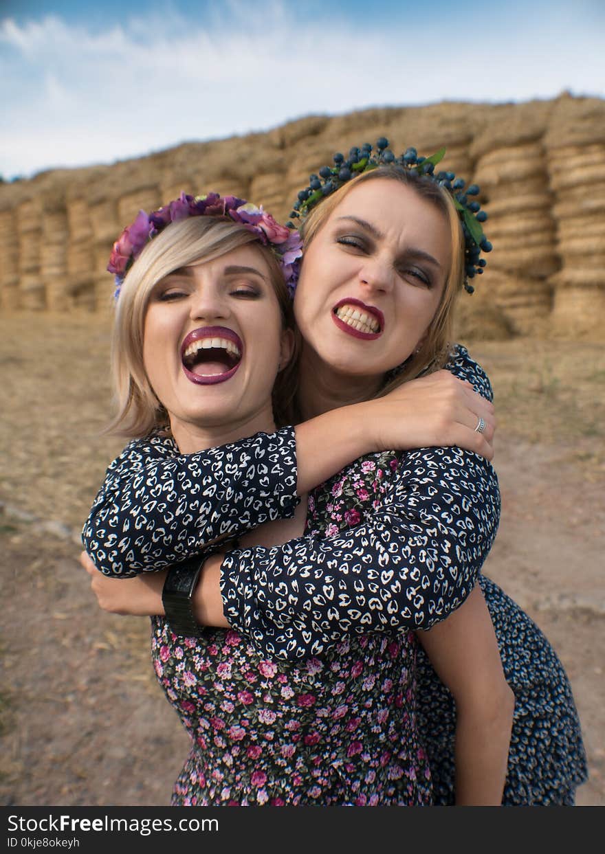 Couple of young lesbian girls laught in light dresses flirt, play laught and pet in the pasture in hayloft in