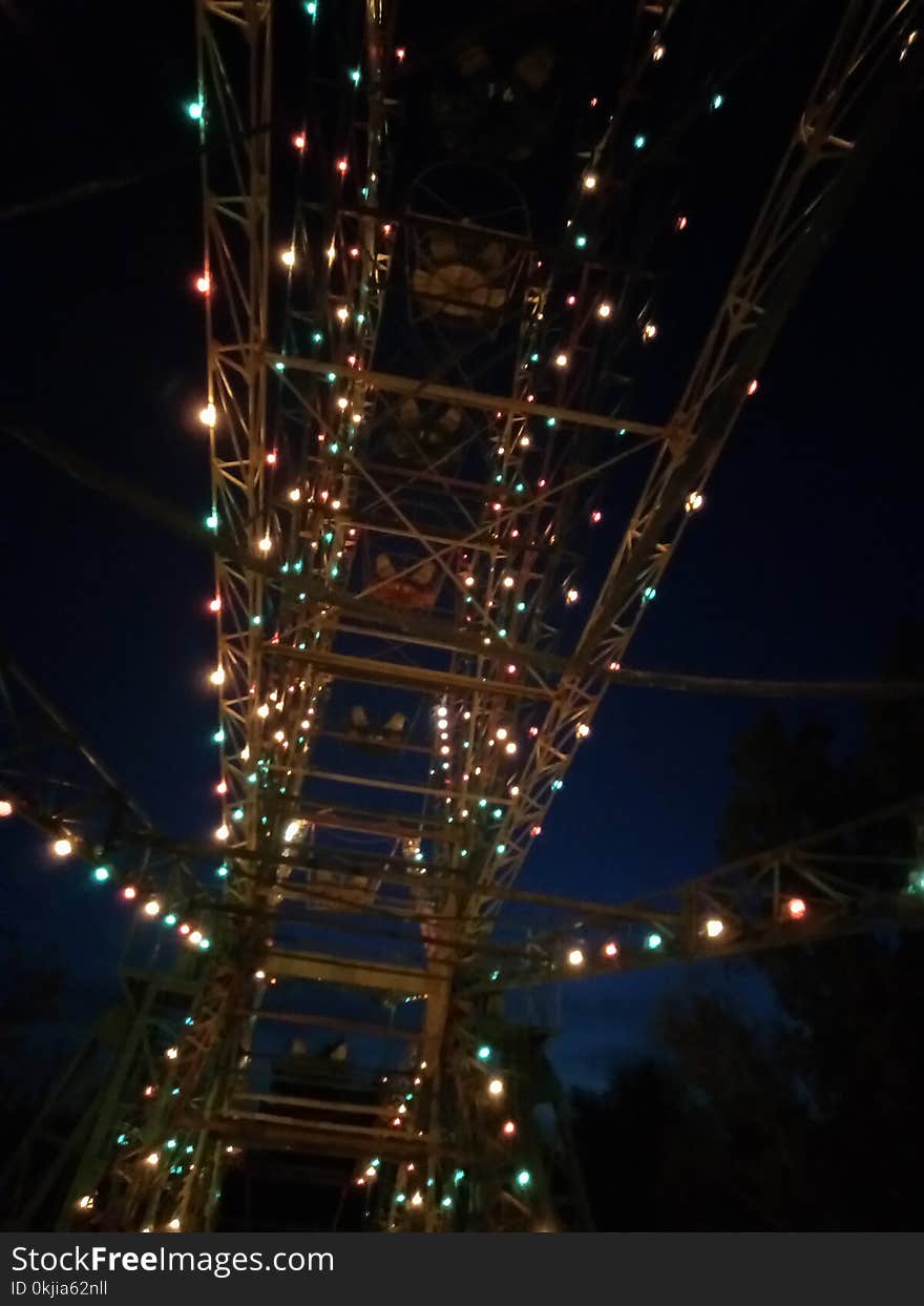 Ferris wheel at night. Flashing lights. Climb.