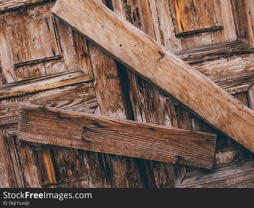 Selective Photo of Two Brown Wood Lumbers barring a door