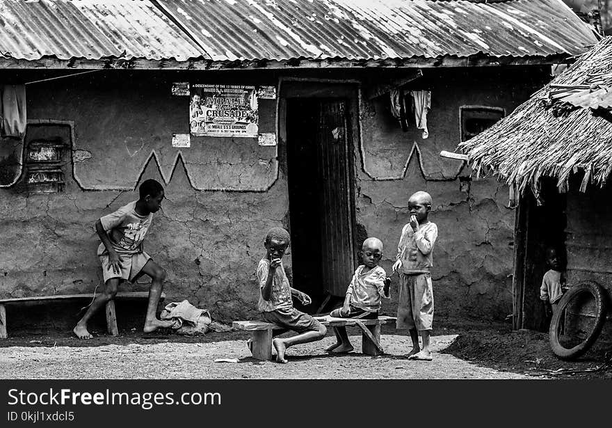 Greyscale Photo of Children in Front of a House at Daytime