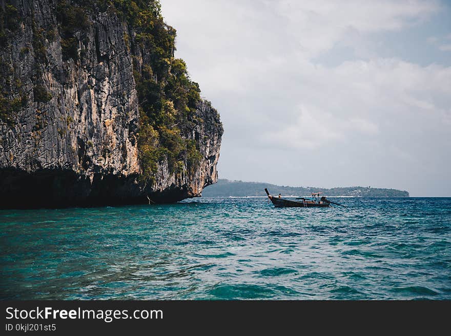 Boat Beside Cave on Body of Water