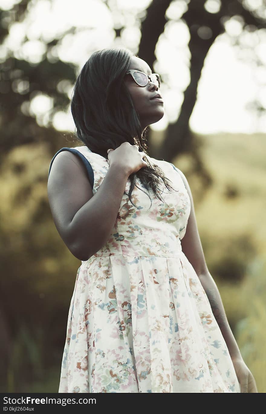 Woman Wearing White and Beige Floral Dress Holding Her Hair