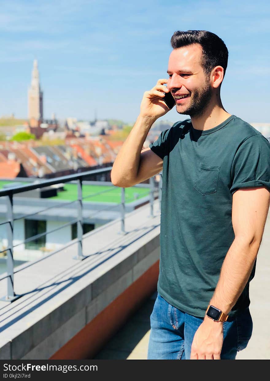 Man Wearing Black Crew-neck Shirt Holding Mobile Phone