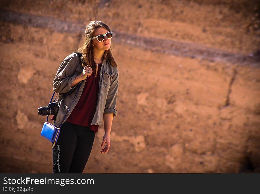 Woman Wearing Brown Jacket With Blue Leather Crossbody Bag