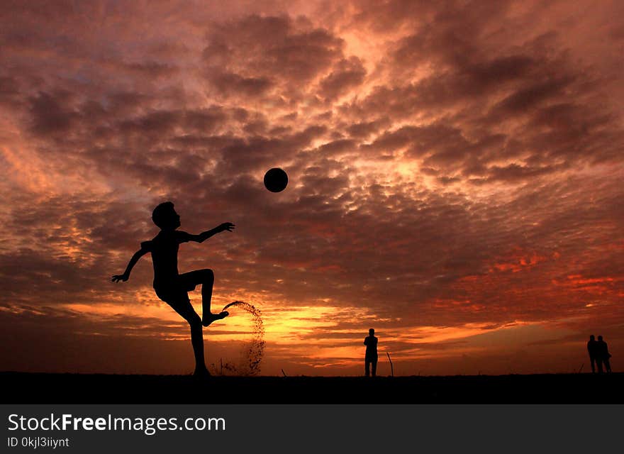 Silhouette of a Boy Playing Ball during Sunset