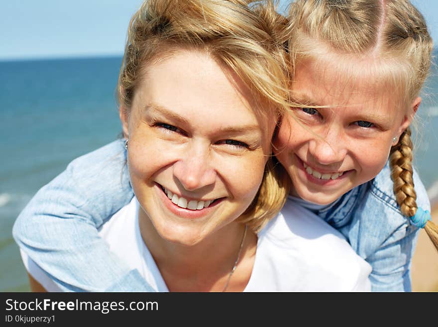 Happy mother and daughter laughing together outdoors.