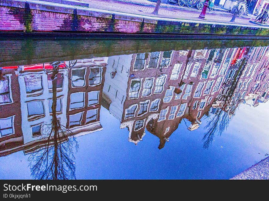 Houses reflected in Amsterdam canal at dusk