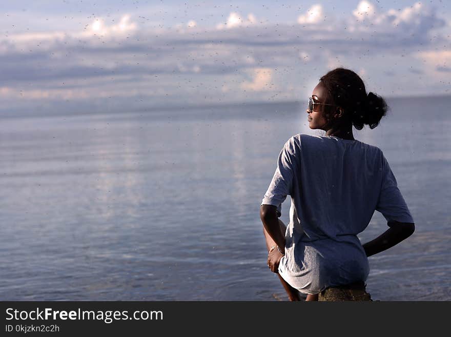 Woman Sitting by the Ocean