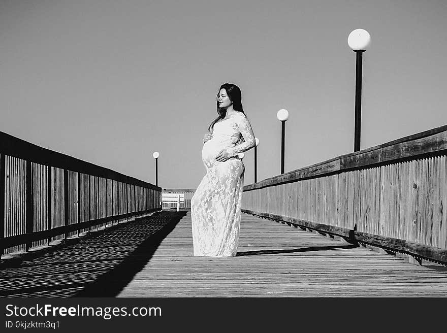 Grayscale Photo of Pregnant Woman Wearing Maxi Dress