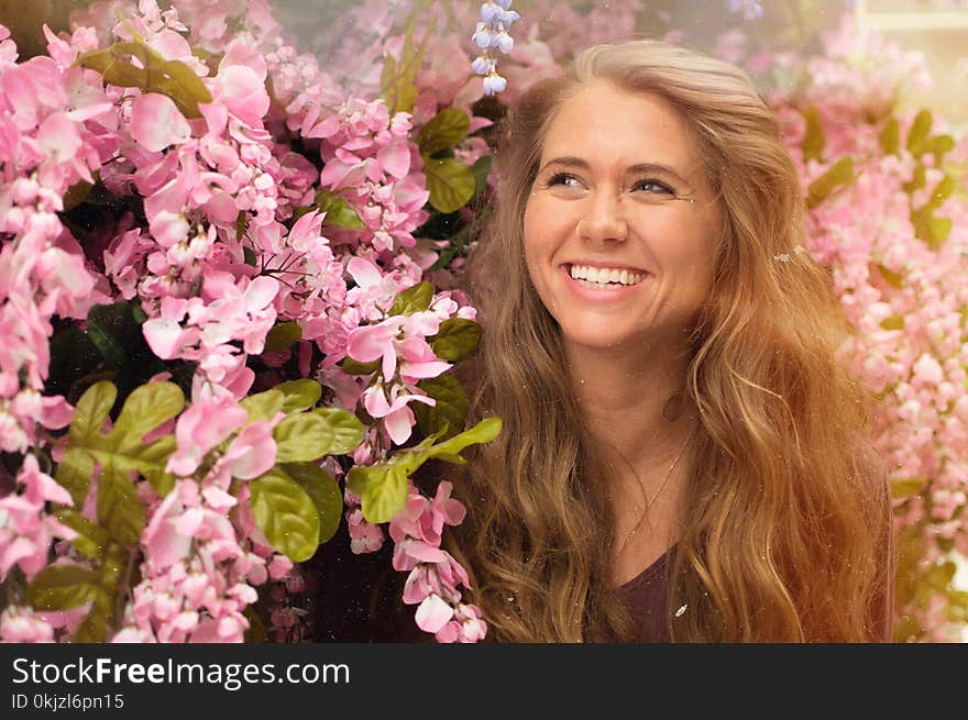 Photo of Woman Standing Beside Pink Flowers