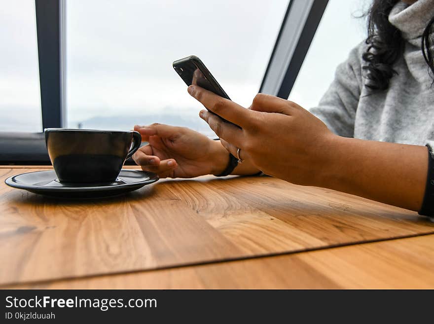 Person Holding Ceramic Cup on Table