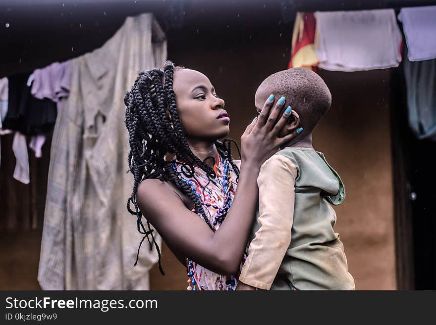 Girl With Braided Hair Standing While Carrying Boy Wearing Beige Long-sleeved Top