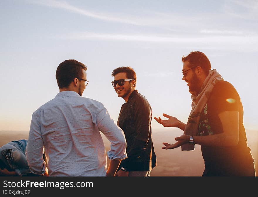 Three Men Standing While Laughing