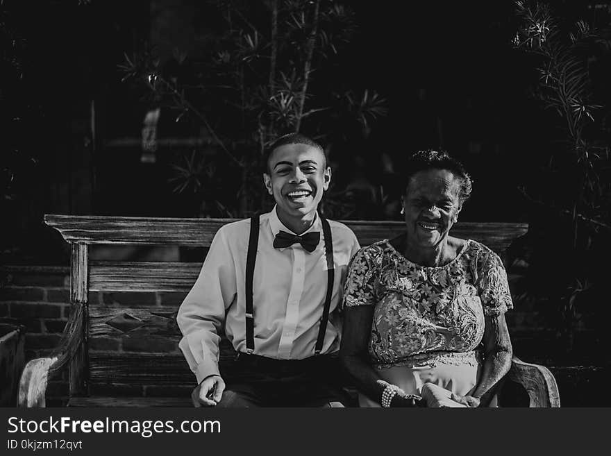 Man and Woman Sitting on Bench in Grayscale Photography