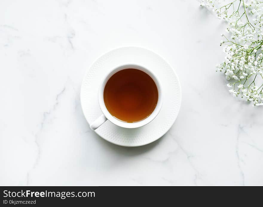 White Ceramic Teacup on Saucer With Brown Liquid