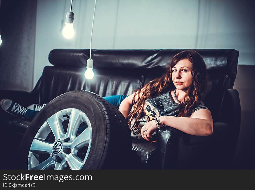 Woman Lying in Black Leather Couch