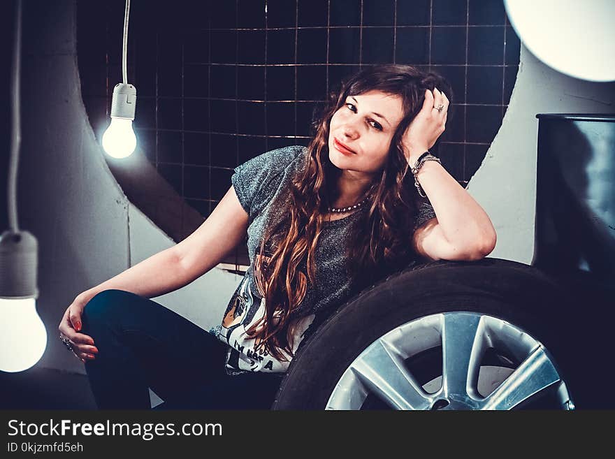 Woman in Gray Top Beside of Wheel With Tire